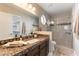 This bathroom features a granite vanity, tile floors, glass shower door and octagonal window at 368 Legacy Dr, Henderson, NV 89014