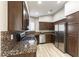 Well-lit kitchen featuring granite countertops, stainless steel appliances, and dark wood cabinetry at 368 Legacy Dr, Henderson, NV 89014