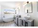 Bathroom with double vanity, soaking tub, and large window at 3695 Funston Way, Las Vegas, NV 89129