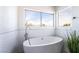 Freestanding bathtub with chrome faucet and tiled accent wall at 3695 Funston Way, Las Vegas, NV 89129