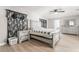 Spacious bedroom with a bed, gray dresser, and black and white paisley curtains at 3695 Funston Way, Las Vegas, NV 89129