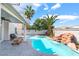 Backyard pool with rock waterfall feature, palm trees, and covered patio at 3695 Funston Way, Las Vegas, NV 89129