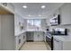 Modern kitchen with stainless steel appliances, white cabinets, and quartz countertops at 3800 Summer Breeze Cir, Las Vegas, NV 89108