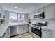 Modern kitchen with stainless steel appliances, white cabinets, and quartz countertops at 3800 Summer Breeze Cir, Las Vegas, NV 89108