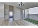 Open living room with wood-look flooring, neutral paint, patio access, and modern lighting at 3800 Summer Breeze Cir, Las Vegas, NV 89108