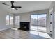 Living room with wood-look floors, fireplace, and large windows with backyard view at 3800 Summer Breeze Cir, Las Vegas, NV 89108