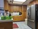 This kitchen has an updated stainless fridge and golden cabinets with tile flooring at 3987 Saddlewood Ct, Las Vegas, NV 89121