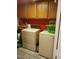 This laundry room has a neutral colored washer and dryer and red painted walls at 3987 Saddlewood Ct, Las Vegas, NV 89121
