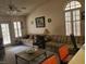 Cozy living room featuring large windows with shutters, a ceiling fan, and comfortable furniture at 3987 Saddlewood Ct, Las Vegas, NV 89121