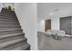Carpeted staircase ascends to a living room with wood-look floors and modern accent wall at 471 Secret Cove Ct, Henderson, NV 89002