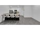 Open concept living room with bright white walls, gray laminate flooring, and kitchen view at 471 Secret Cove Ct, Henderson, NV 89002