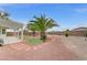 Spacious backyard featuring desert landscaping, mature palm trees, and a covered patio with ample space for outdoor entertaining at 4910 Cielo Ct, Pahrump, NV 89061
