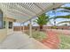 Backyard view showcasing the covered patio, desert landscaping, and mature trees, creating a perfect space for outdoor relaxation at 4910 Cielo Ct, Pahrump, NV 89061