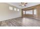 Spacious living room featuring wood-look floors, ceiling fan, and bright windows at 4910 Cielo Ct, Pahrump, NV 89061