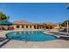 Outdoor community swimming pool area with lounge chairs and a beautiful building at 4910 Cielo Ct, Pahrump, NV 89061