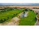 Beautiful aerial view of a lush green golf course with scenic lakes and mature trees at 4914 E Beacon Ridge Dr, Pahrump, NV 89061