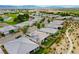 Panoramic aerial showcasing suburban homes and lush green golf course and pond at 4914 E Beacon Ridge Dr, Pahrump, NV 89061