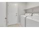 Laundry room featuring a white door, a shelf, and modern washer and dryer at 523 Rancho Del Norte Dr, North Las Vegas, NV 89031