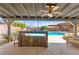 Outdoor seating area with ceiling fan overlooking the glistening pool at 5361 Cabrito Dr, Las Vegas, NV 89103