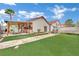 Spacious backyard with artificial grass, a covered patio, and room for entertaining and recreation at 5512 Kettering Pl, Las Vegas, NV 89107
