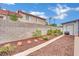 Landscaped backyard showcasing desert landscaping along a brick wall and flower bushes at 5512 Kettering Pl, Las Vegas, NV 89107