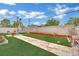 Landscaped backyard featuring artificial grass, a stone pathway, and space for outdoor activities at 5512 Kettering Pl, Las Vegas, NV 89107
