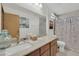 Well-lit bathroom featuring a granite countertop and a shower with dragonfly patterned curtain at 5512 Kettering Pl, Las Vegas, NV 89107