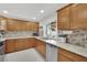 Updated kitchen with ample cabinets, stainless steel appliances, granite countertops, and backyard view at 5512 Kettering Pl, Las Vegas, NV 89107