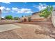 View of the fenced backyard with a low wall, mature landscaping, and small patio at 6525 Bismark Hills St, North Las Vegas, NV 89084