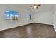A bright bedroom with two windows, ceiling fan, and wood-look flooring at 6525 Bismark Hills St, North Las Vegas, NV 89084