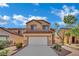 Inviting two-story home featuring a two-car garage and desert landscaping under a beautiful blue sky at 6525 Bismark Hills St, North Las Vegas, NV 89084