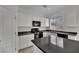 Modern kitchen with white cabinetry, granite countertops, and a black appliance suite at 6525 Bismark Hills St, North Las Vegas, NV 89084