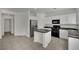 Well-lit kitchen featuring stainless steel refrigerator, black appliances, and a center island at 6525 Bismark Hills St, North Las Vegas, NV 89084