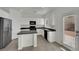 Modern kitchen with white cabinets, black appliances, granite countertops, and tile flooring at 6525 Bismark Hills St, North Las Vegas, NV 89084