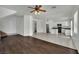 Open-concept living space features wood flooring flowing into a tiled kitchen with white cabinetry at 6525 Bismark Hills St, North Las Vegas, NV 89084