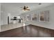 Bright living room with wood floors adjoining tiled kitchen with white cabinetry and stainless appliances at 6525 Bismark Hills St, North Las Vegas, NV 89084