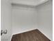 A basic walk-in closet with upper shelving and wood-look flooring at 6525 Bismark Hills St, North Las Vegas, NV 89084