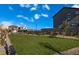 View of the community area with a vast lawn, benches, trellised seating, and landscaping at 6574 Tumoulin St, Las Vegas, NV 89148