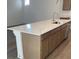 Spacious kitchen island featuring a stainless steel sink, storage cabinets, and a stone countertop at 6574 Tumoulin St, Las Vegas, NV 89148