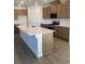 Well-equipped kitchen with an island, stainless steel appliances, and wood cabinetry at 6574 Tumoulin St, Las Vegas, NV 89148