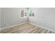 A vacant bedroom space featuring stylish wood-look flooring and an abundance of natural light at 681 Pine Ridge Dr, Las Vegas, NV 89110