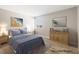 Staged bedroom with blue bedding, wood-look flooring, and natural light at 681 Pine Ridge Dr, Las Vegas, NV 89110