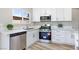 Updated kitchen with stainless steel appliances, quartz countertops, and white cabinets at 681 Pine Ridge Dr, Las Vegas, NV 89110