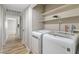 Convenient laundry area including a modern washer and dryer set, shelving, and neutral-toned walls at 681 Pine Ridge Dr, Las Vegas, NV 89110
