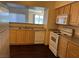 Bright kitchen features wood cabinetry, white appliances, and a stainless steel sink at 6955 N Durango Dr # 1038, Las Vegas, NV 89149