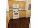 Kitchen with modern white appliances, wood cabinets, and dark wood-look floors at 6955 N Durango Dr # 1038, Las Vegas, NV 89149
