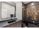 Sleek bathroom featuring modern dark cabinets, a sink, toilet, and bathtub with a dark metal shower at 7185 Ranchito Cir, Las Vegas, NV 89120