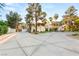Luxury home with circular driveway, palm trees, lush landscaping, and gated entrance at 7185 Ranchito Cir, Las Vegas, NV 89120