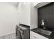 Laundry room area with a sink, washer, dryer, and white cabinets at 7185 Ranchito Cir, Las Vegas, NV 89120