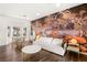 Bright living room featuring a large accent wall, white couch, hardwood floors, and windows at 7185 Ranchito Cir, Las Vegas, NV 89120
